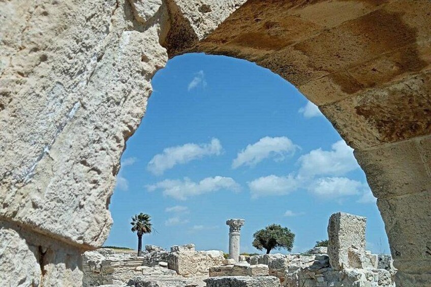 Ancient ruins with stone columns and an arched opening. 5