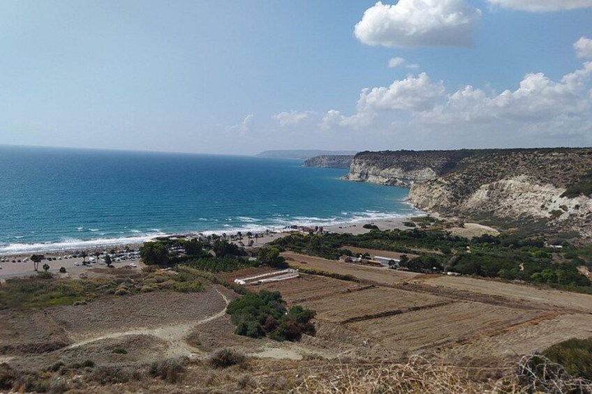 A coastal landscape with a beach, cliffs, and agricultural fields. 1