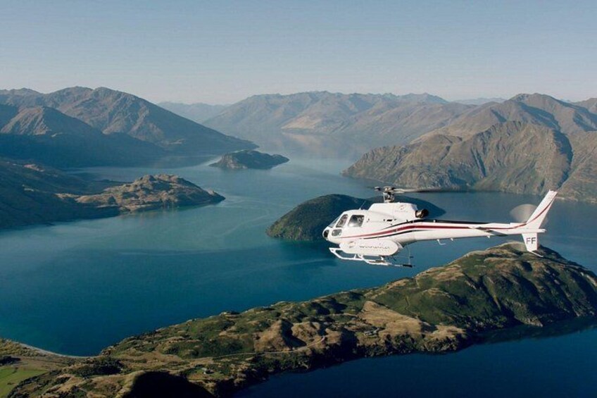 Un helicóptero volando sobre un lago rodeado de montañas. 2