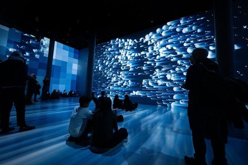 A large digital display with a grid of illuminated spheres in a dark room. 2
