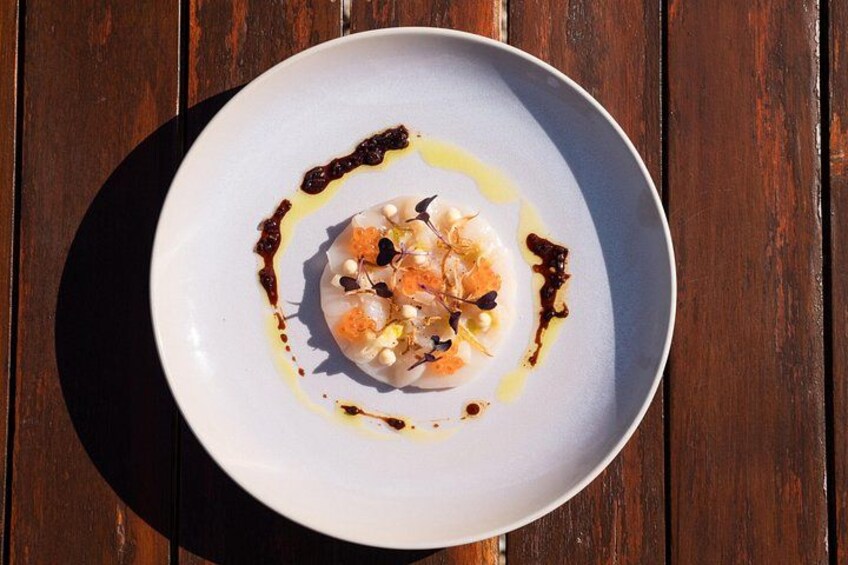 A white plate with a seafood dish on a wooden table. 5