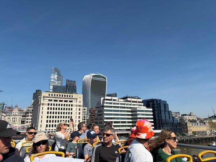 A group of people on a sightseeing boat with a city skyline in the background. 2