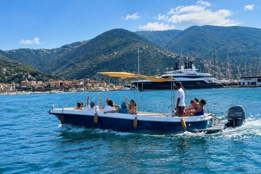 A boat with people on a clear day, surrounded by water and mountains. 2