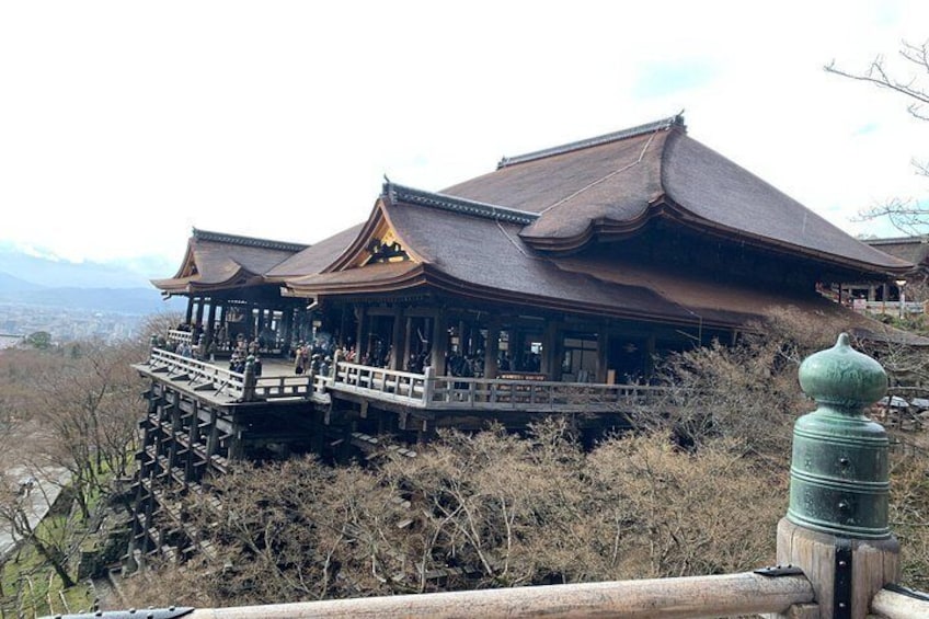 A traditional Japanese building with a wooden structure and a thatched roof, surrounded by dry vegetation. 2
