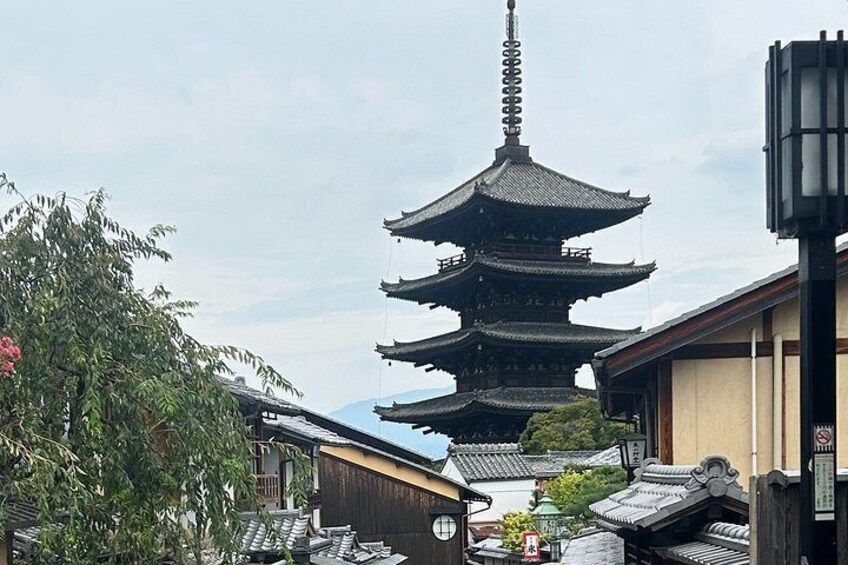 A traditional Japanese pagoda with multiple tiers, surrounded by traditional buildings and greenery. 4