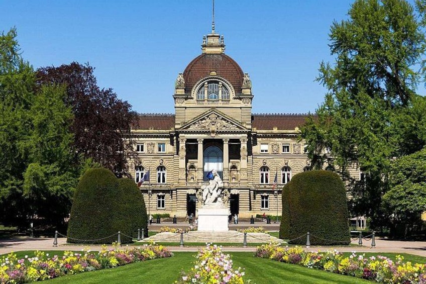 A grand building with a dome, statues, and a well-maintained garden. 2
