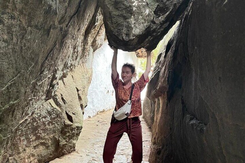 A person standing in a narrow canyon with large rock formations on either side. 3