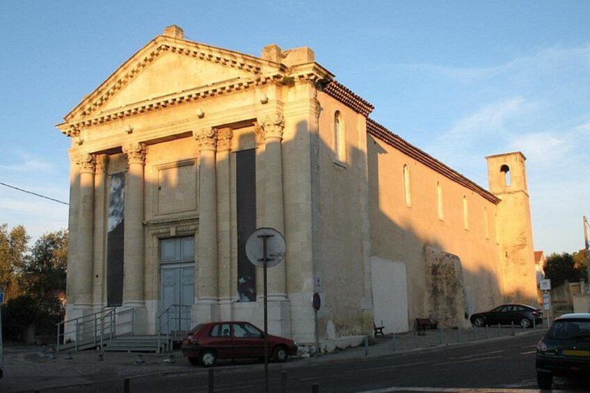 Un edificio neoclassico con colonne, una torre dell'orologio e una strada con auto. 2