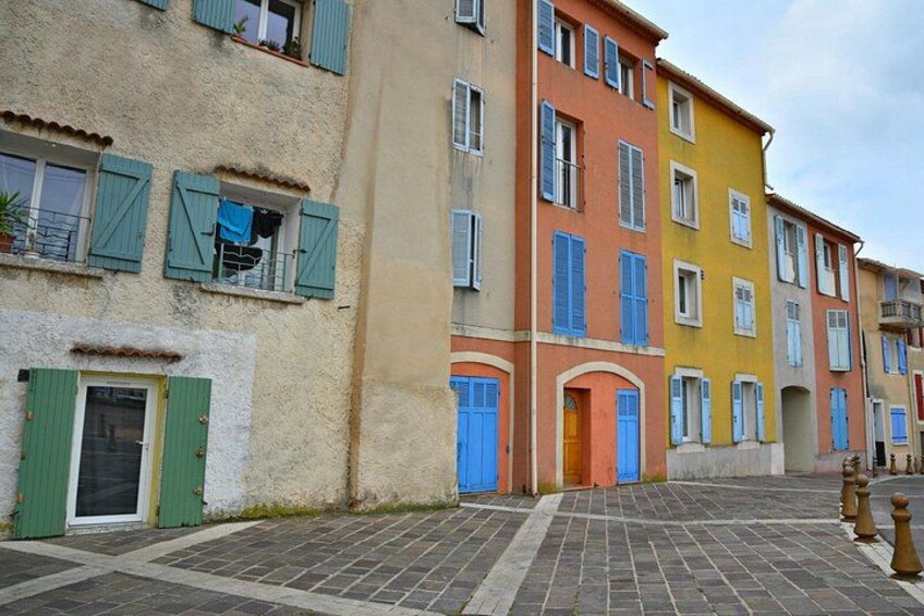 Una strada acciottolata con edifici colorati, persiane e porte. 4