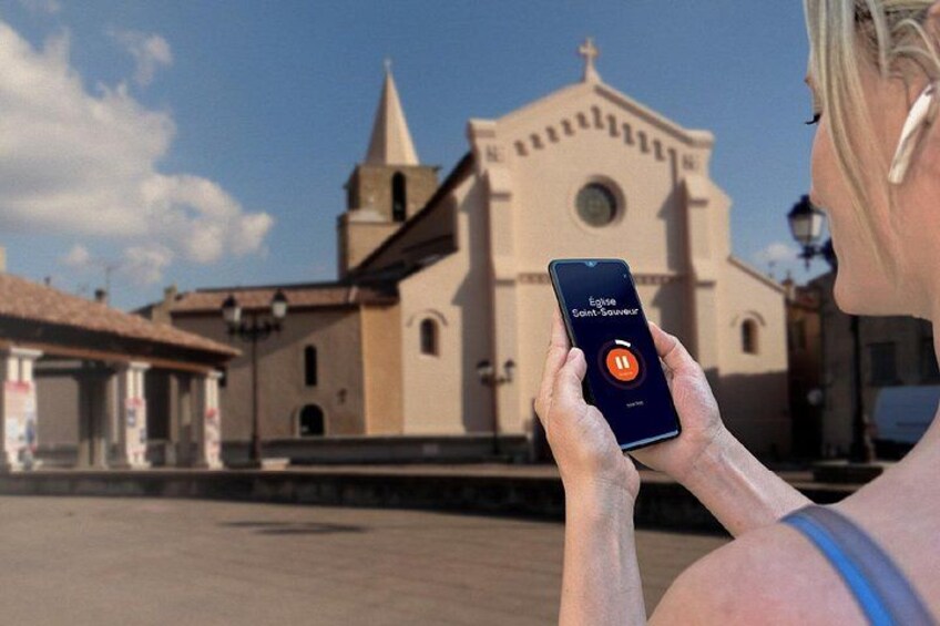 Una persona che tiene in mano uno smartphone con un'applicazione mappe, una chiesa con un campanile e un cielo sereno. 5