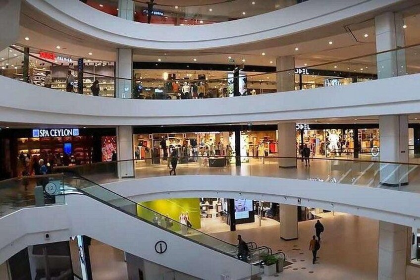 A multi-level shopping mall with stores and escalators. 3
