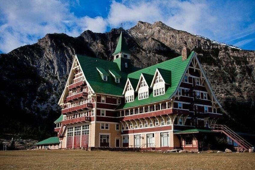 A traditional chalet with a steep roof, set against a mountainous backdrop. 3