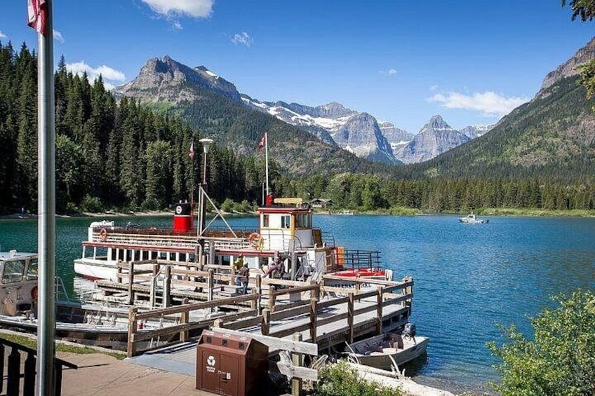 A lake with a docked boat, mountains in the background, and a clear sky. 4