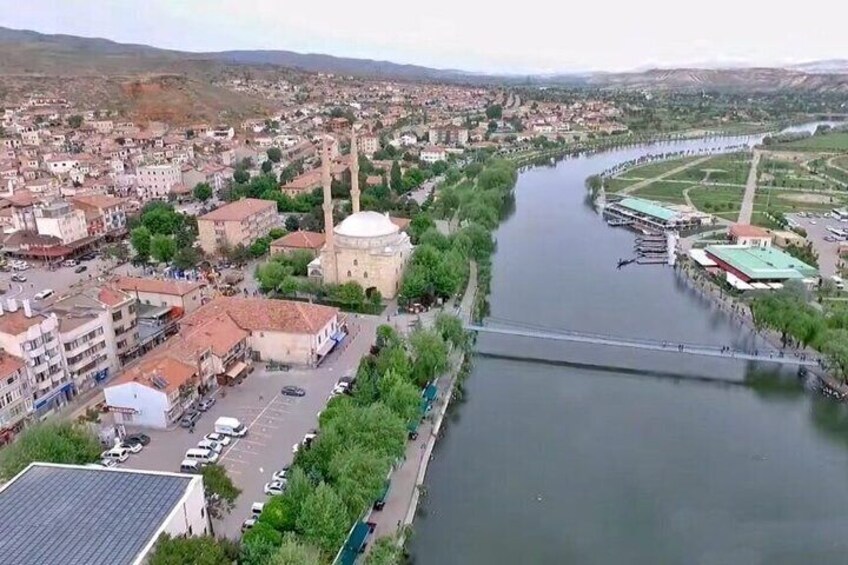 A river flowing through a city with buildings, a mosque, and a bridge. 5