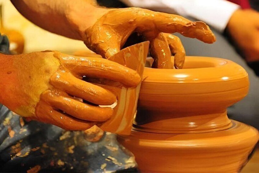 Hands shaping a clay pot on a potter's wheel. 3