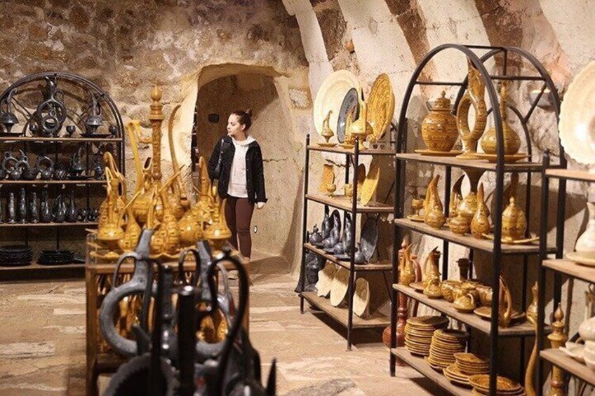 A pottery shop with shelves of ceramic items and a person browsing. 2