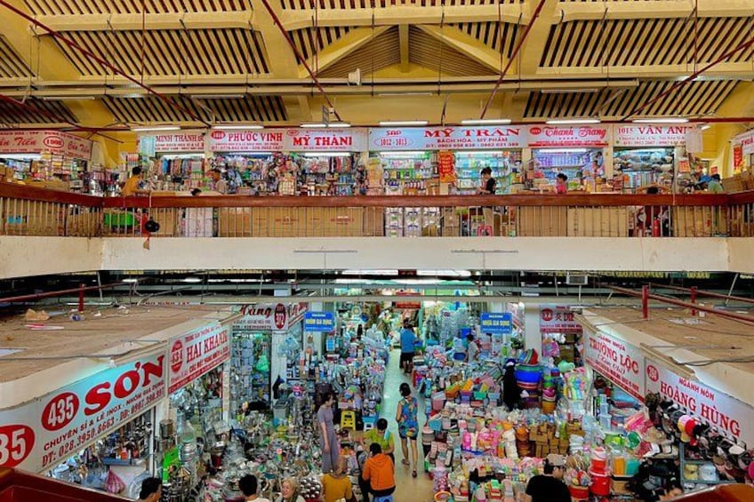 Un marché intérieur à plusieurs niveaux, avec différents stands et panneaux indicateurs. 4