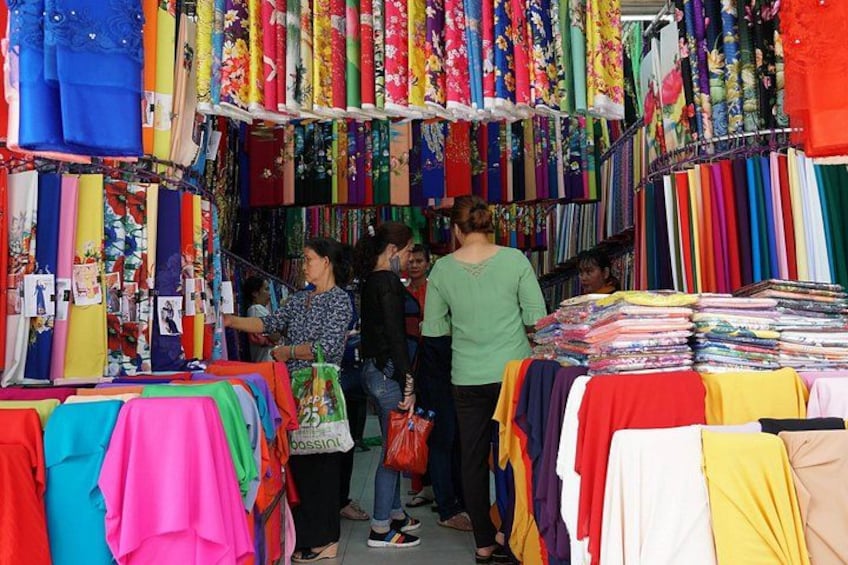 Un marché de tissus où sont exposés des textiles aux couleurs vives. 5