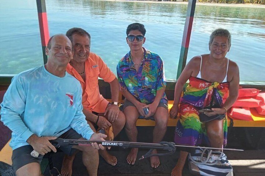 Four people on a boat, one holding a fishing rod. 4