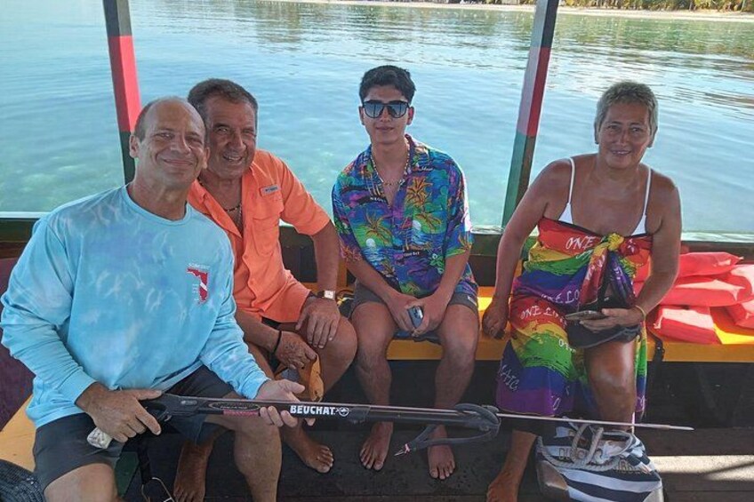 Quatre personnes se trouvent à bord d’un bateau, avec une étendue d’eau en arrière-plan. 4