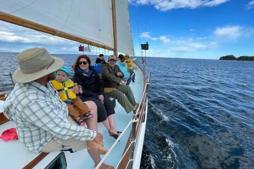 People on a sailboat with a child in a life jacket. 1