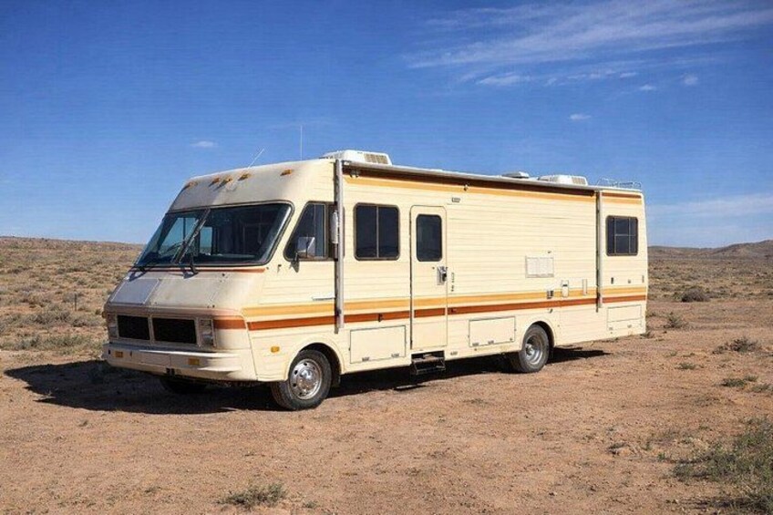 Una caravana recreativa color beige estacionada en un paisaje desértico. 3