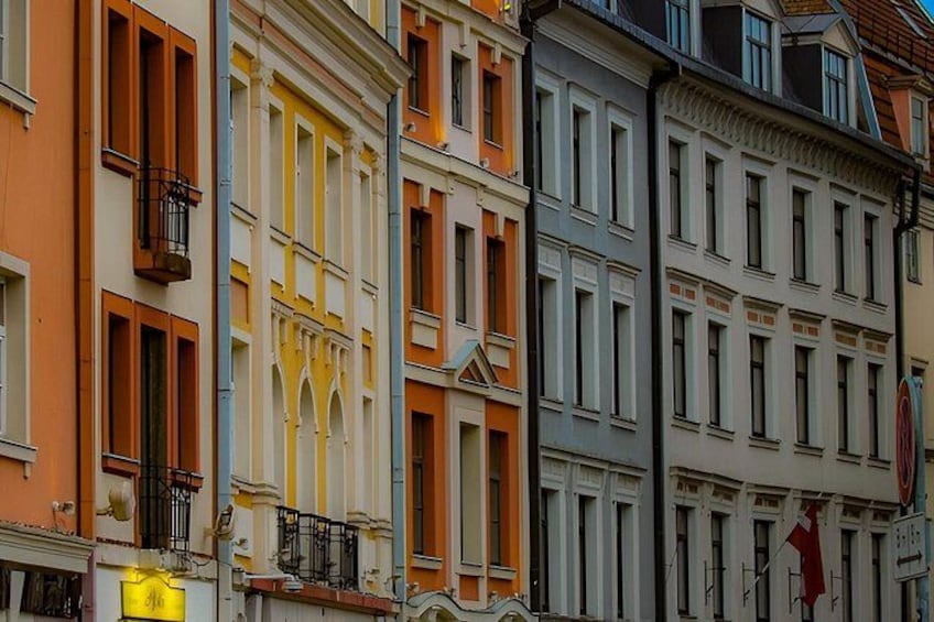 Une rangée de bâtiments aux couleurs vives, chacun présentant un style architectural distinct et doté de balcons. 2