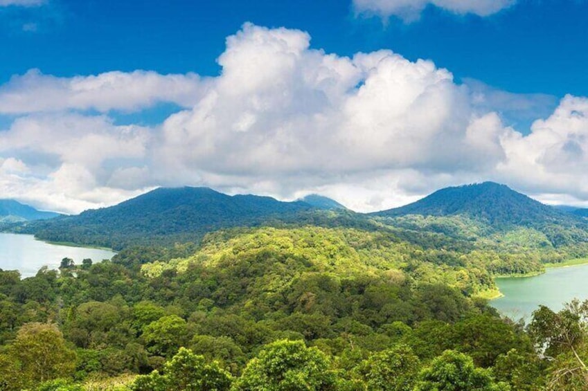 Un paisaje montañoso con bosques verdes y un lago. 5