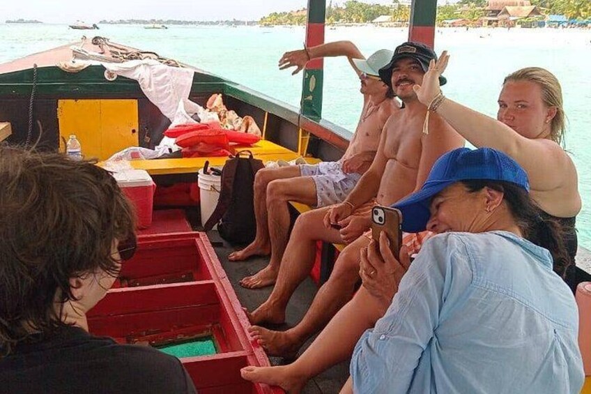 Folk på en båd med udsigt til havet og en fjerntliggende ø. 3