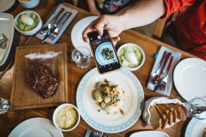 A person taking a photo of food with a smartphone. 2