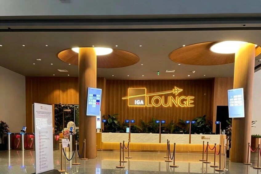 An ICA lounge with a wooden reception desk, digital screens, and a modern ceiling design. 3