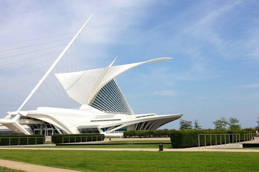A modern white building with a unique sail-like structure. 1