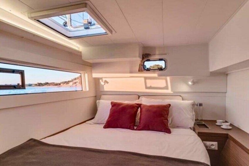 A bedroom with a bed, a TV, and a window overlooking the sea. 3