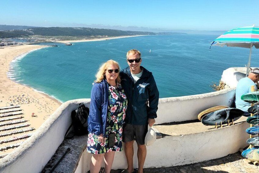 Et kystlandskab med strand, hav og en person stående på en klippe. 2