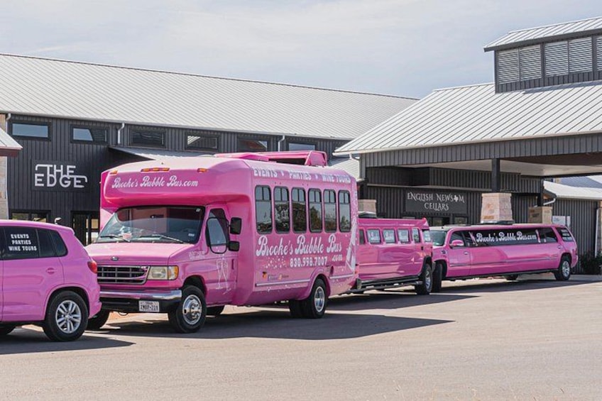 A pink food truck parked in front of a building with signage. 3