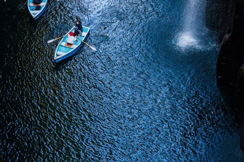 A person paddling a small boat on a calm body of water. 3