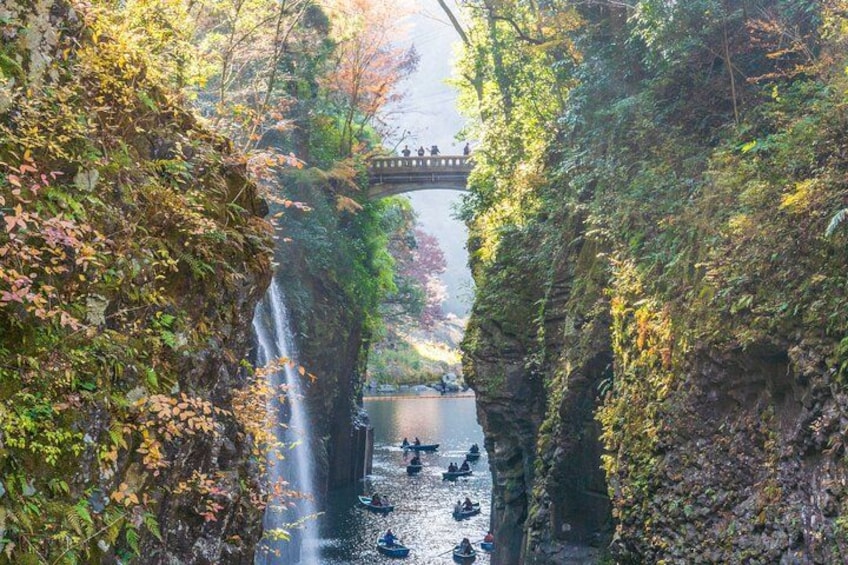 A waterfall, a bridge, and a river with boats. 1