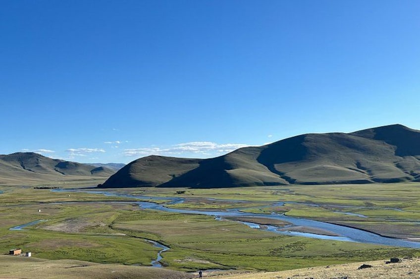 A river winding through a valley with rolling hills in the background. 2