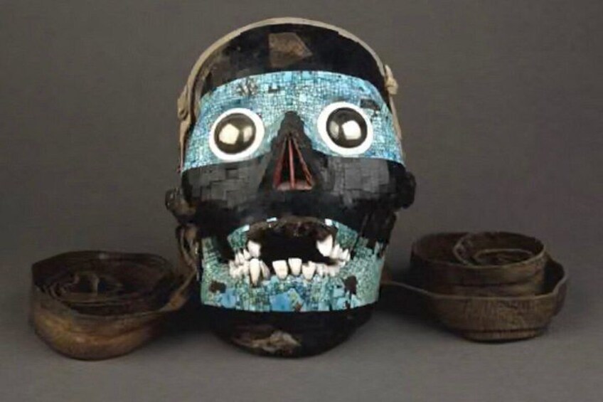 A mask with a blue and black design, featuring large eyes and a mouth with teeth. 1