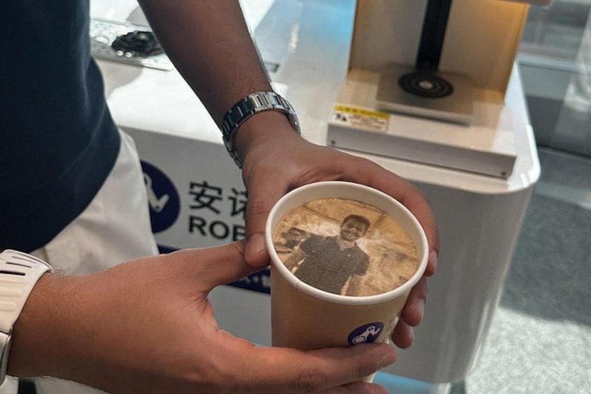 A person holding a cup with a printed image on it. 5
