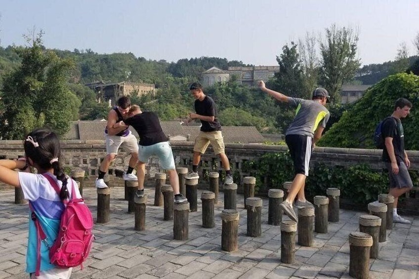 People performing a balancing act on wooden posts. 2