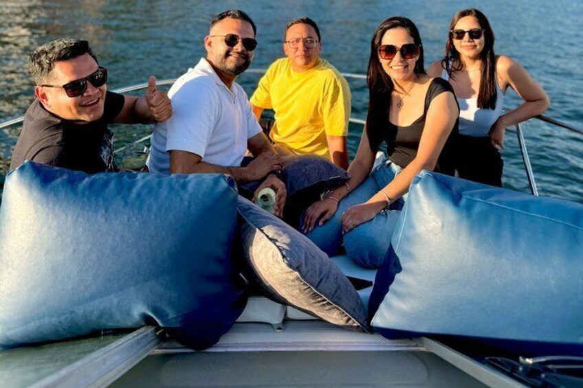 A group of people on a boat with blue cushions. 4