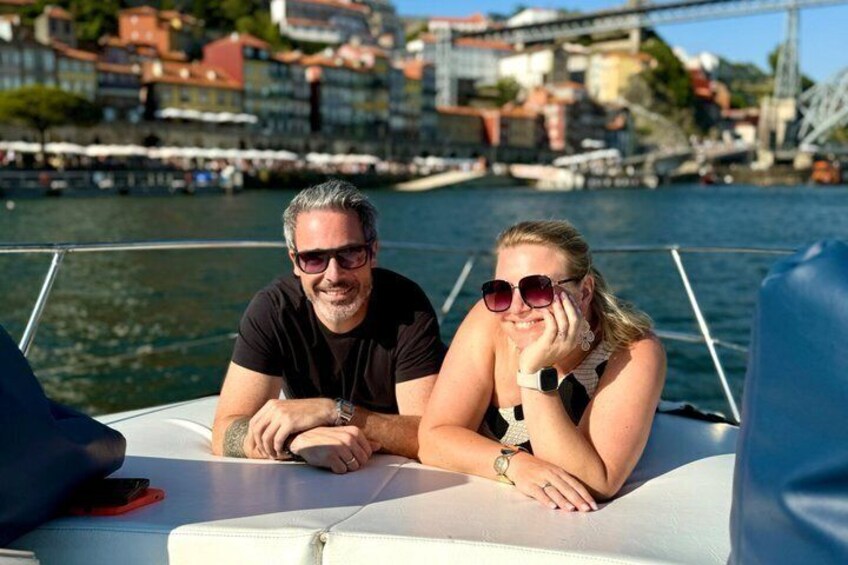 Two people on a boat with a cityscape in the background. 2