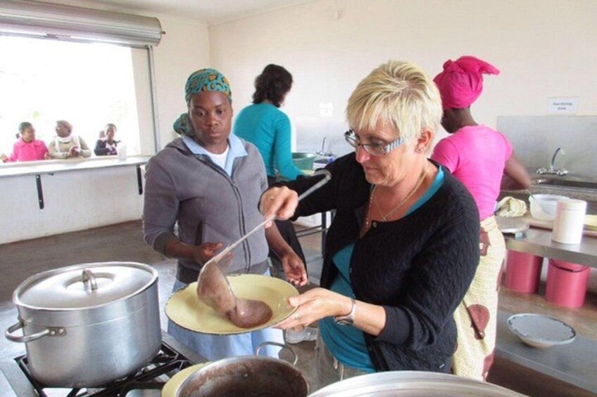 A cooking class with participants preparing food in a kitchen. 3