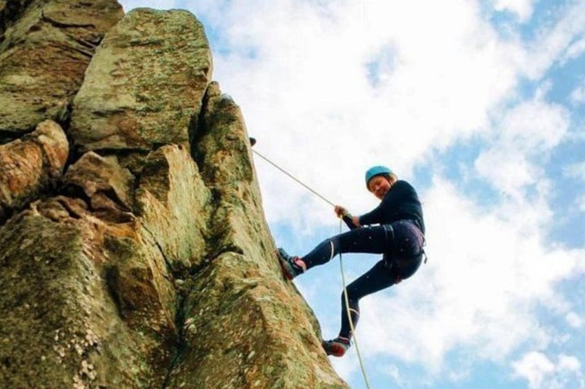 A person rappelling down a rocky cliff. 1
