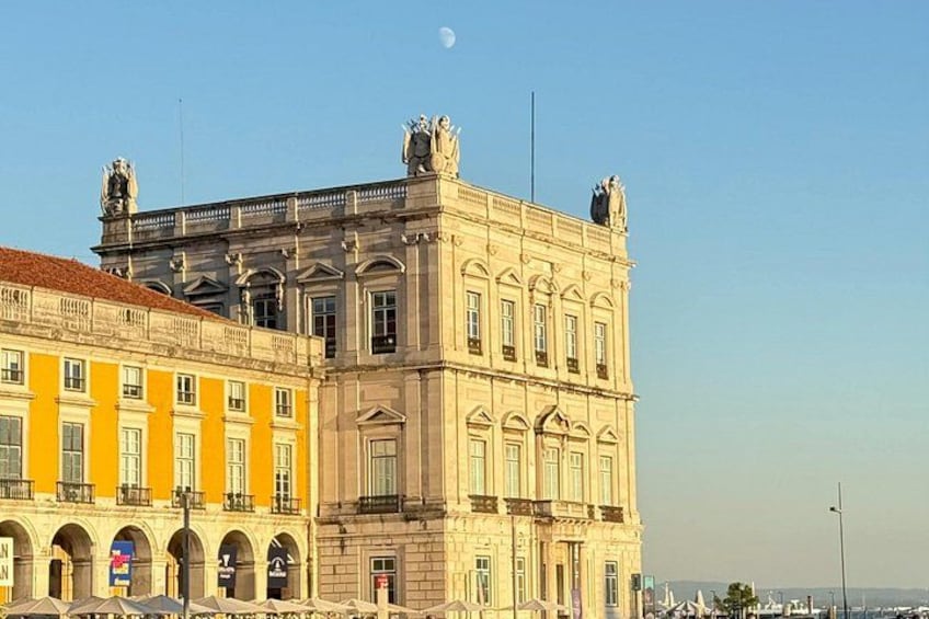 A historic building with classical architecture, a clear sky, and a crescent moon. 1