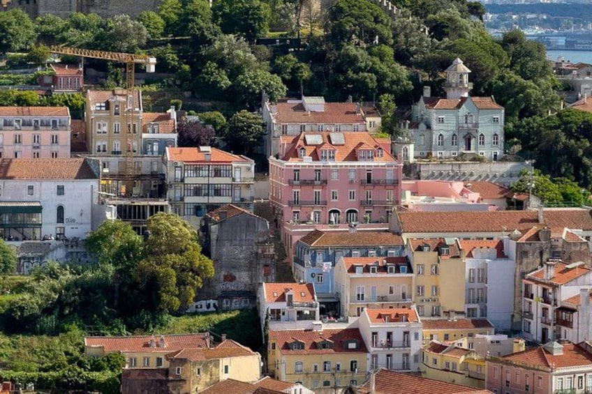 A densely built urban area with historic buildings, a prominent church, and a hilltop structure. 2