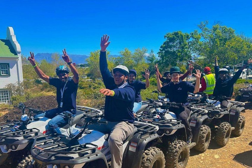A group of people on ATVs in a rural setting with a clear sky. 2