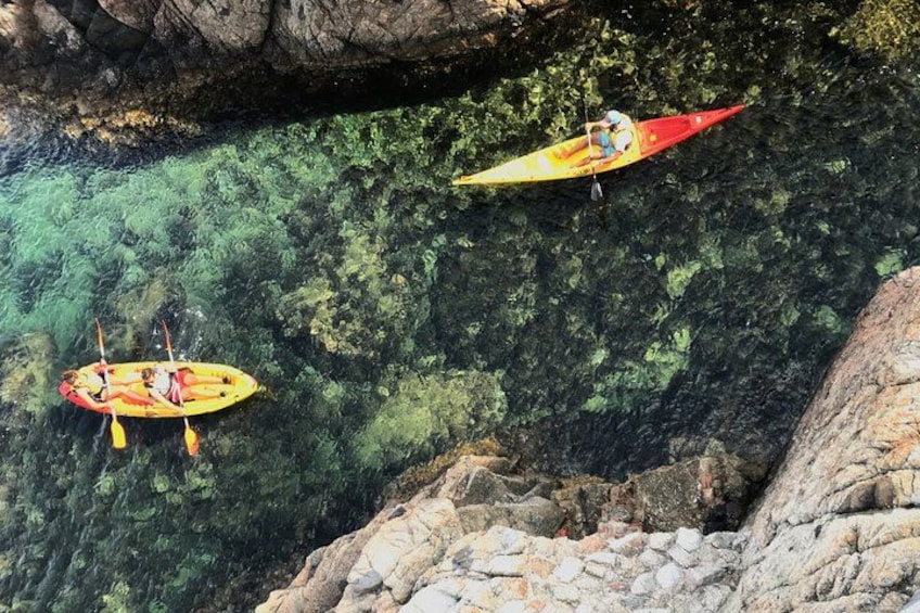 Two kayaks on a clear water body surrounded by rocky terrain. 5