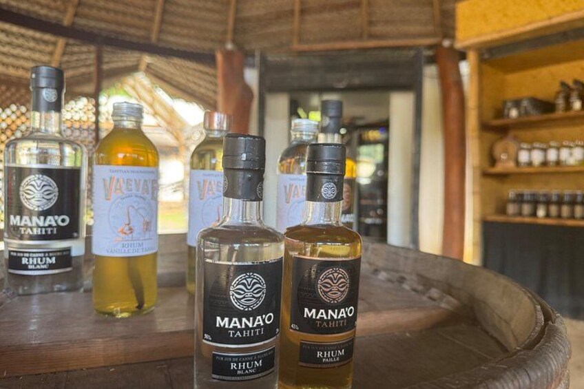 Bottles of rum on a wooden table with a thatched roof background. 2